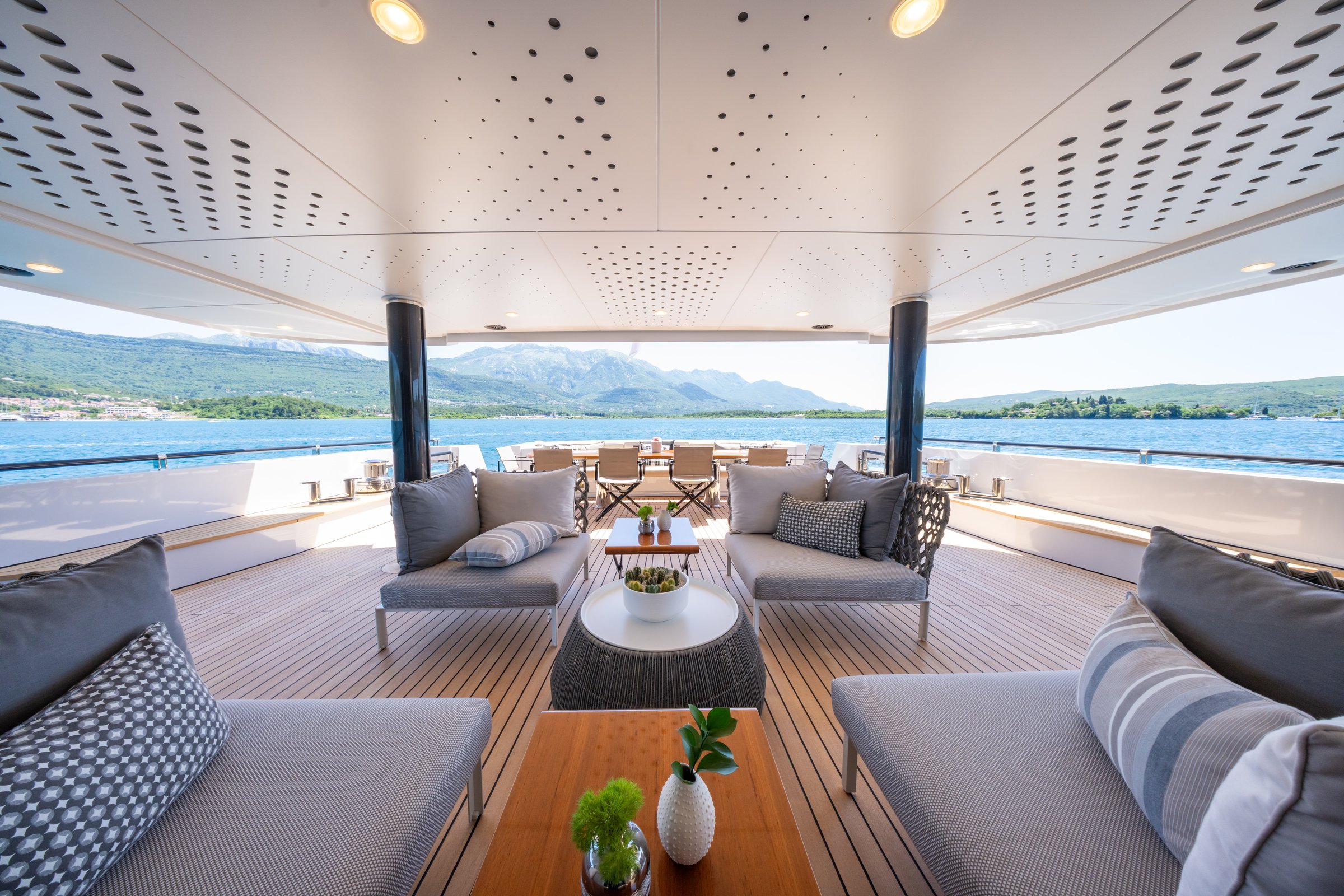 Shaded deck lounge on AQUARIUS with dining beyond and mountain views
