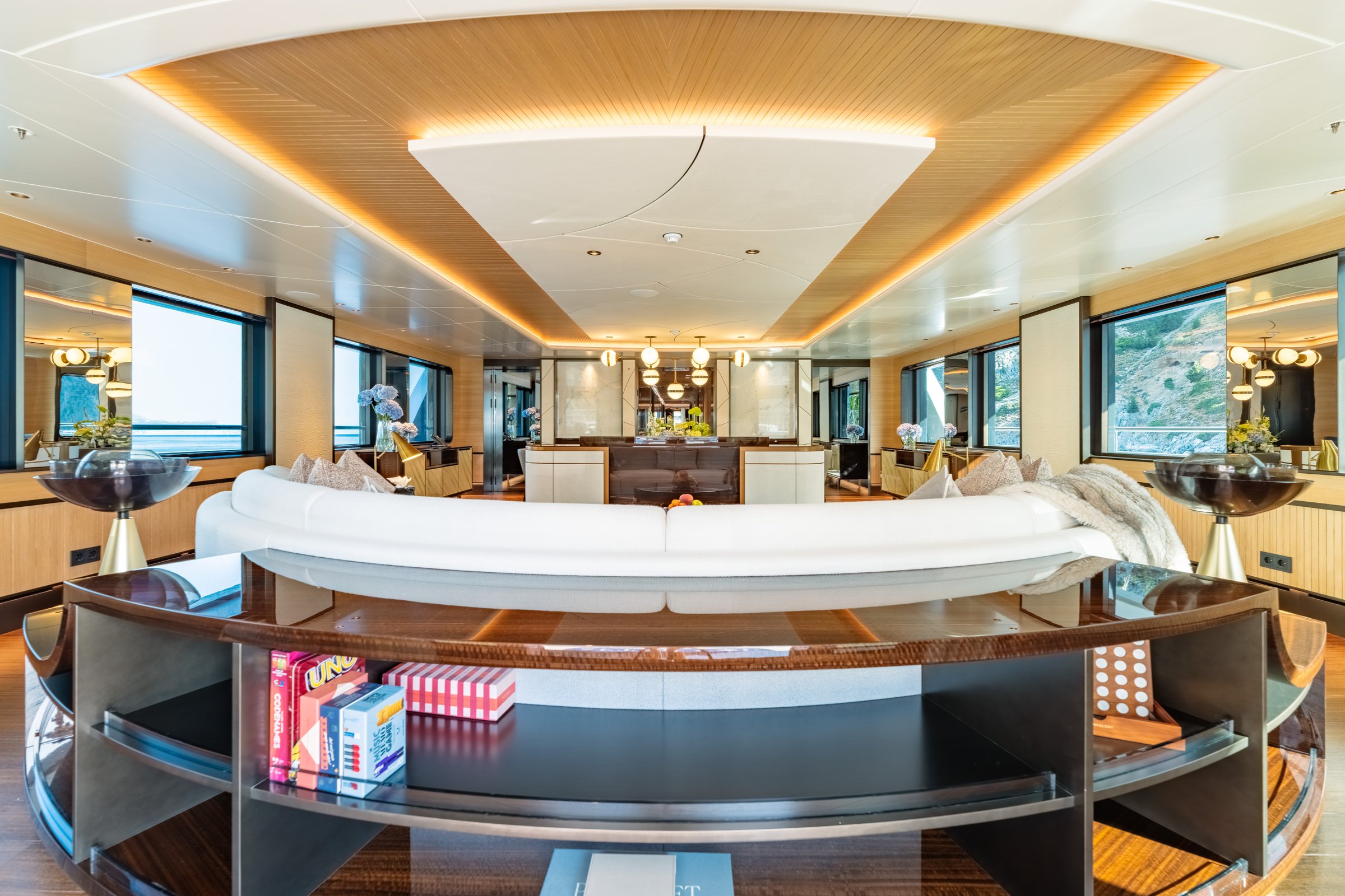 AFTER YOU — Main salon with curved sofa and coastal windows