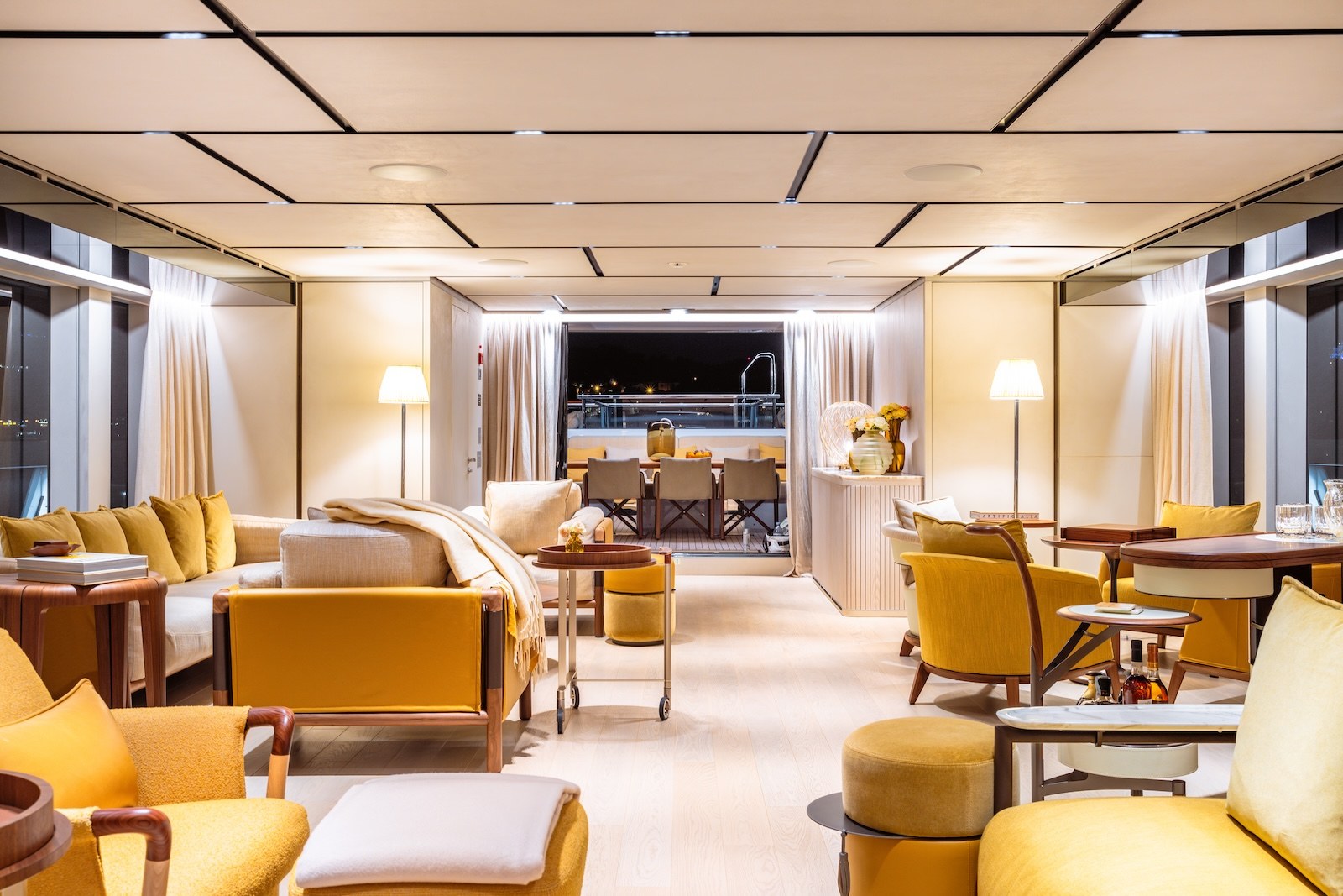 R.M.F main salon with mustard seating opening to the aft deck
