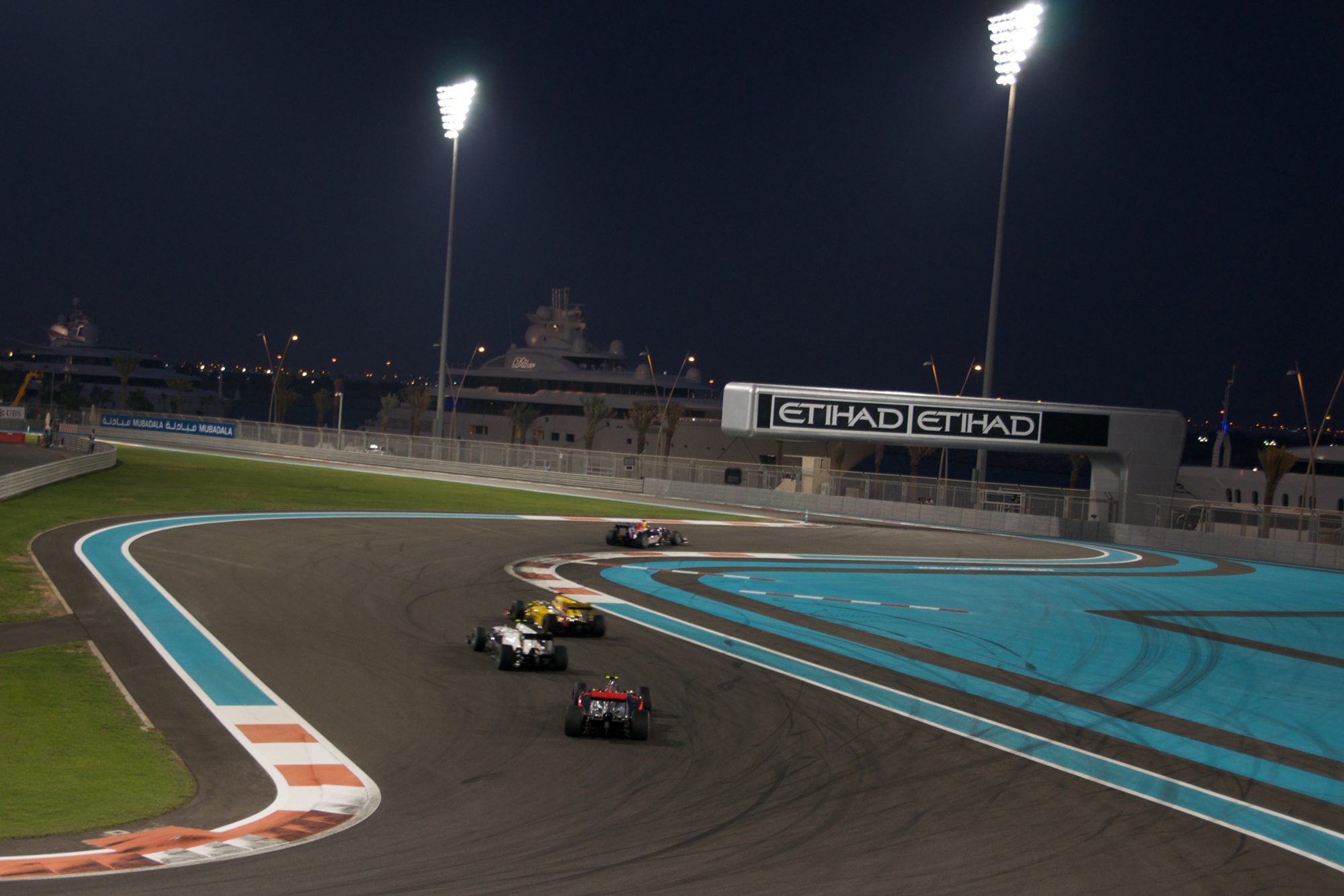 Yas Marina Circuit at night, with the circuit lights reflected in the water