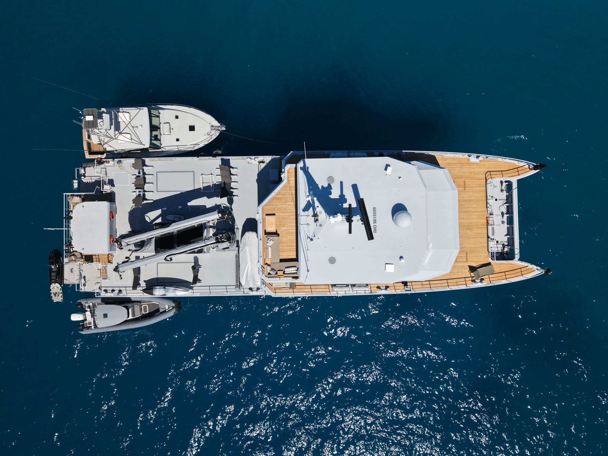 Overhead aerial plan view of 2B at anchor with the 13-metre sport fisher and amphibious tender stowed on deck