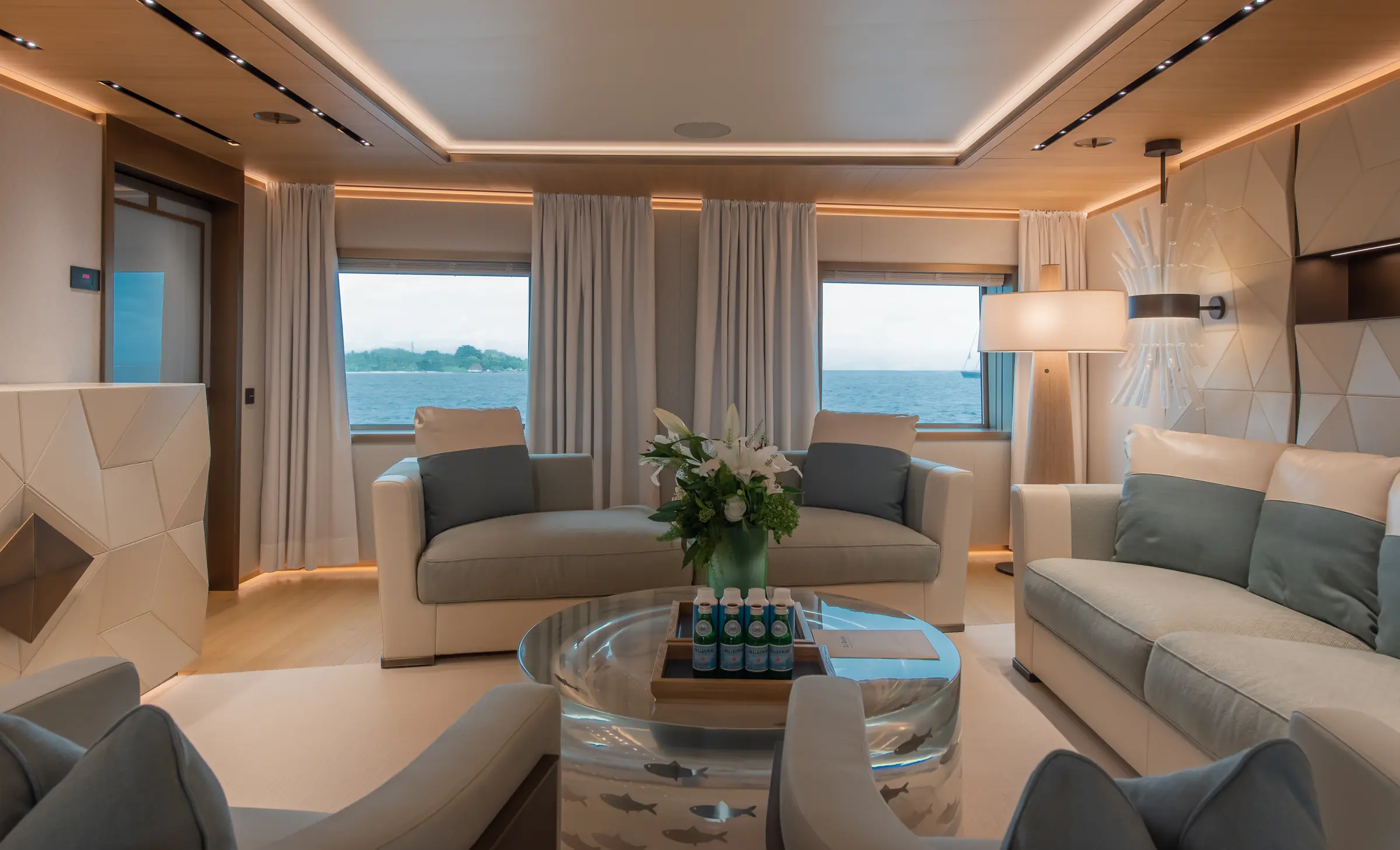 Private lounge aboard LA DATCHA with pale sofas and sea views