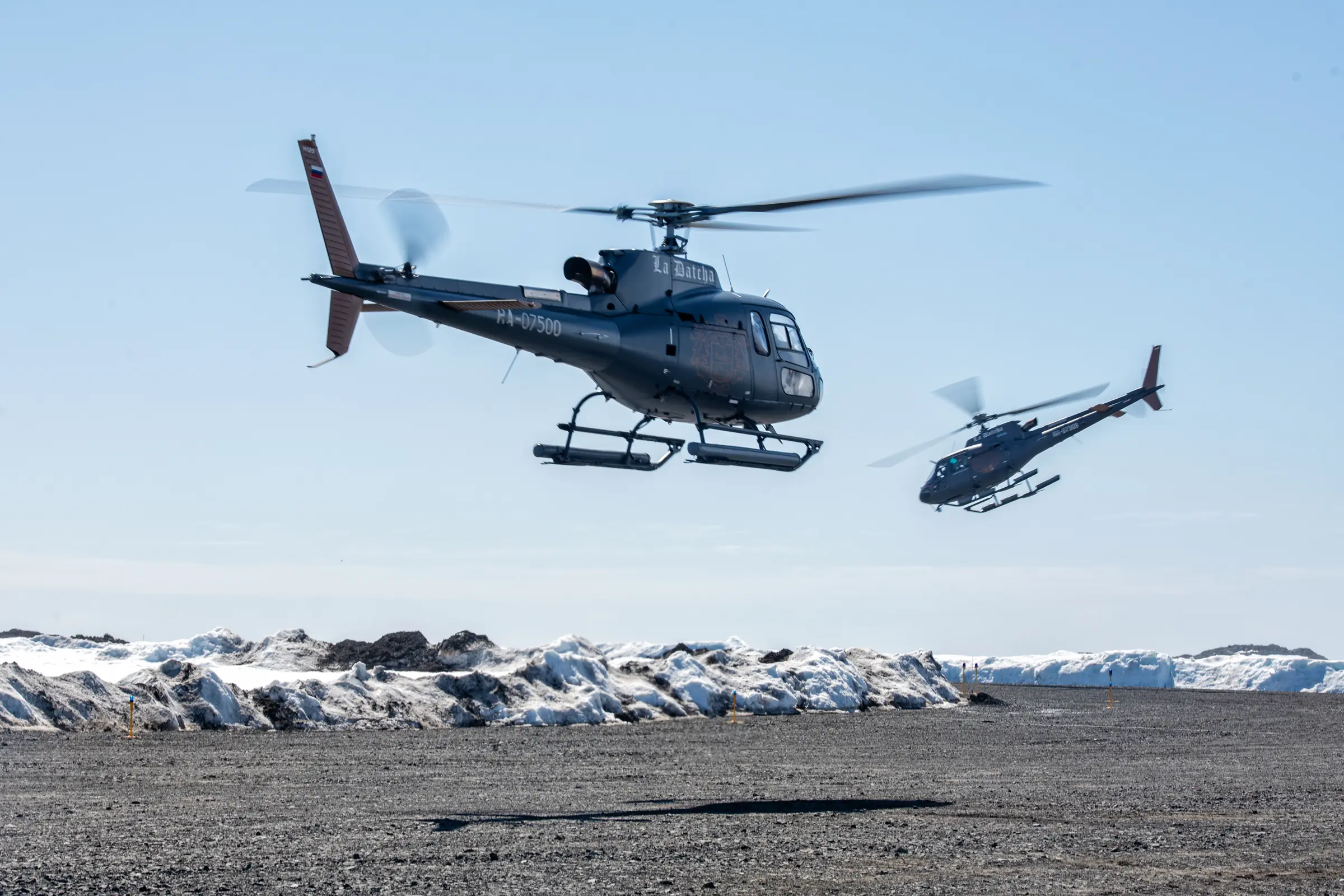 Two helicopters flying over a polar landscape during a LA DATCHA expedition
